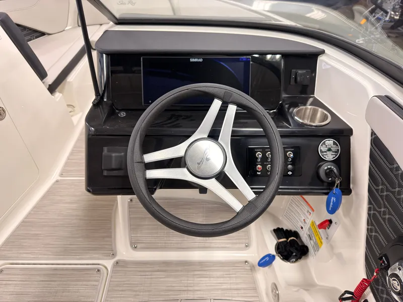Slide: The Image of The image shows the helm of a Sea Ray SPX 210 boat with a modern dashboard. - 28