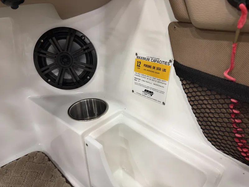 Slide: The Image of Interior of a Cobalt 200 boat with speaker, cup holder, and capacity label. - 36