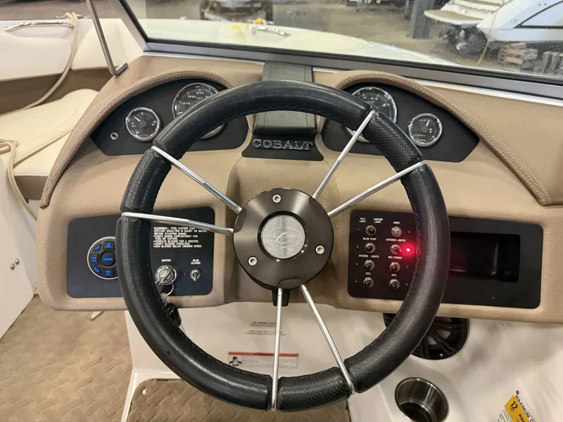 Slide: The Image of The image shows the cockpit of a 2015 Cobalt 200 boat with a black steering wheel. - 28