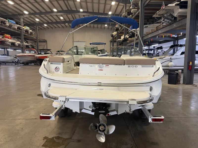 Slide: The Image of Rear view of a 2015 Cobalt 200 boat in a storage facility, featuring a blue sunshade. - 3