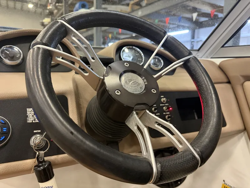 Slide: The Image of The image shows the steering wheel of a 2015 Cobalt 200 boat with instruments in the background. - 29