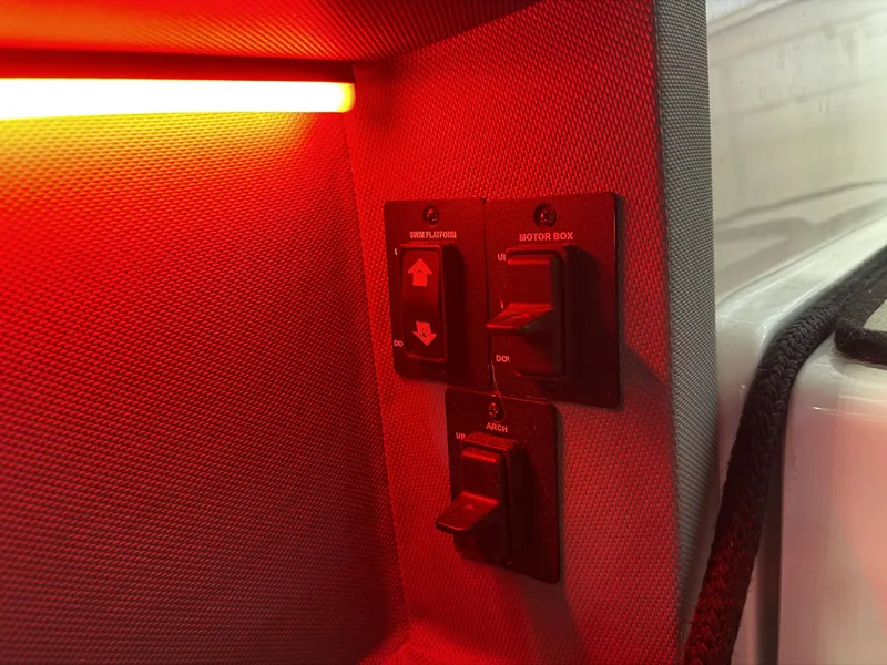 Slide: The Image of A lit control panel with switches for motor box and anchor on a Cobalt R30 boat. - 30