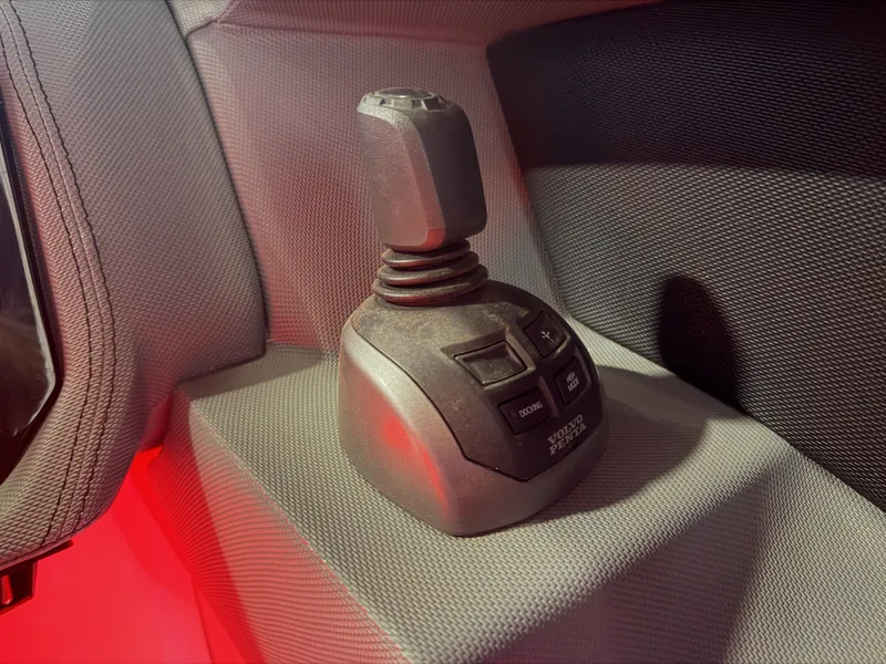 Slide: The Image of A control lever with multiple buttons on a textured surface inside a boat. - 41