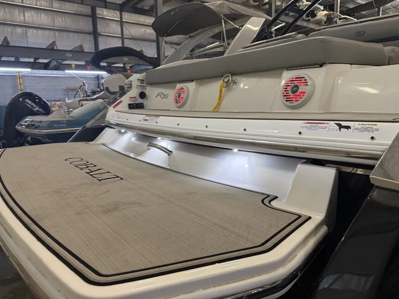 Slide: The Image of The image shows the stern of a 2022 Cobalt R30 boat in a storage facility. - 9