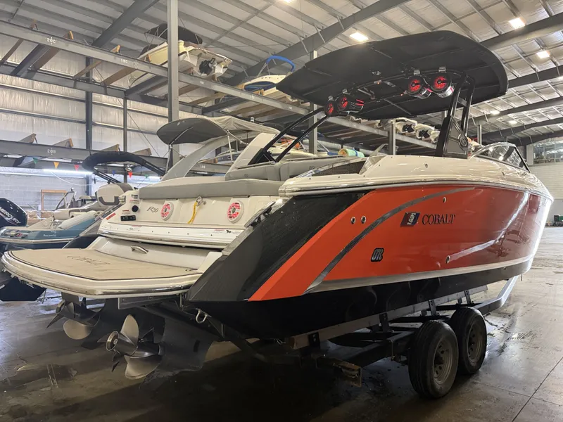 Slide: The Image of A 2022 Cobalt R30 boat in a warehouse. It features a striking orange design. - 5