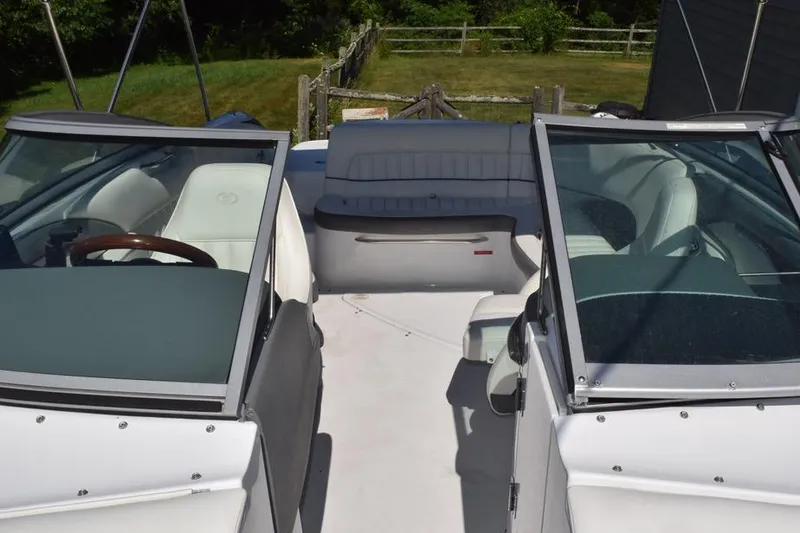 Slide: The Image of 2006 Cobalt 240 boat interior with white seating and dual windshields. - 11