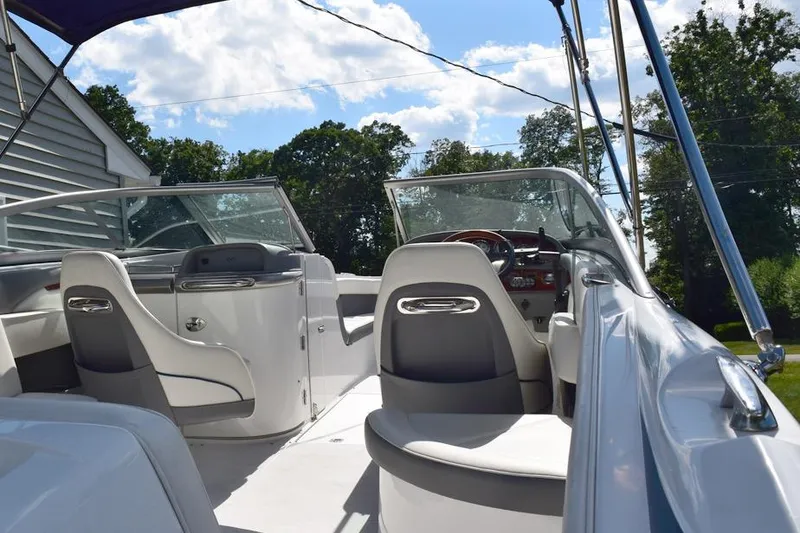 Slide: The Image of 2006 Cobalt 240 boat interior with seating and steering wheel under blue sky. - 9