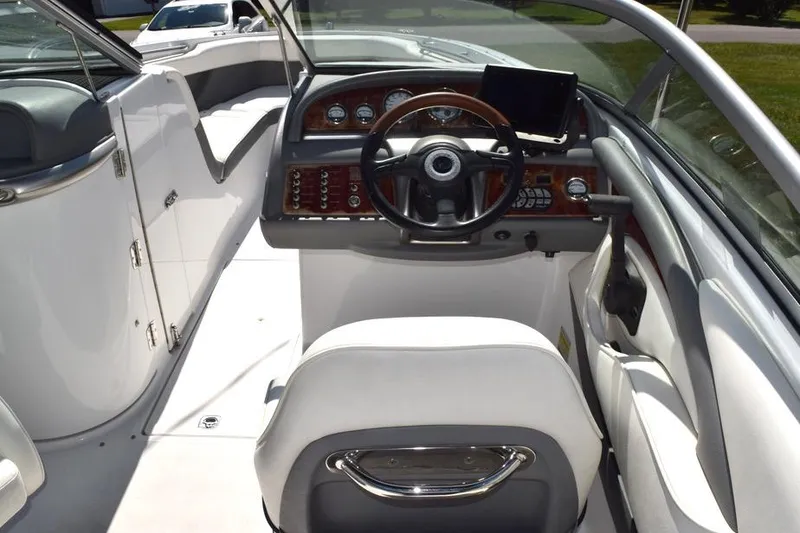 Slide: The Image of Interior view of a 2006 Cobalt 240 boat cockpit with steering wheel and dashboard controls. - 7