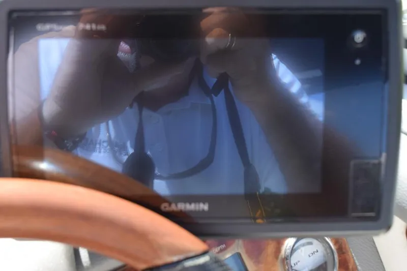 Slide: The Image of Garmin GPS device in a 2006 Cobalt 240 boat cockpit, reflecting a person. - 8