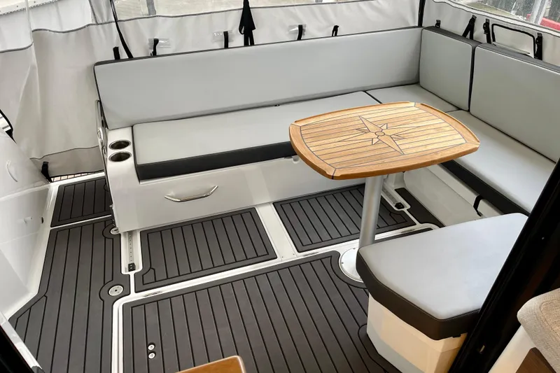 Slide: The Image of 2023 Jeanneau NC Weekender 895 interior with seating and wooden table. - 8
