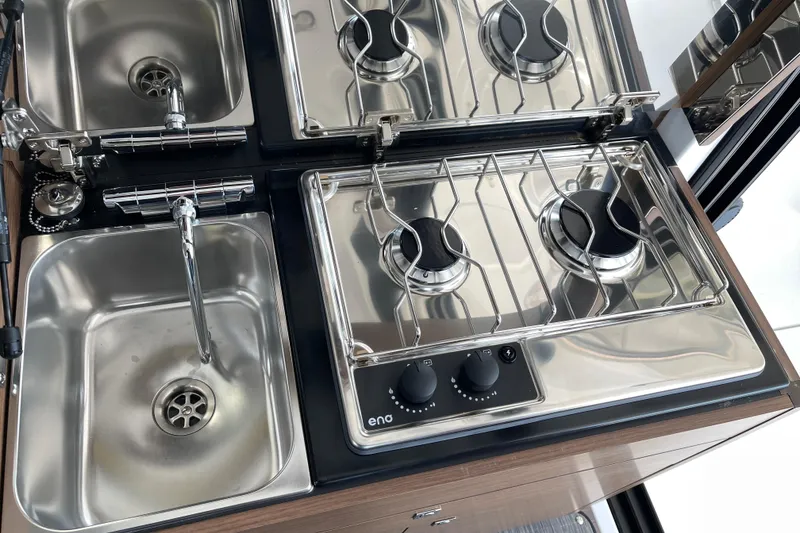 Slide: The Image of Compact kitchen setup in 2023 Jeanneau NC Weekender 895 with sink and dual-burner stove. - 16