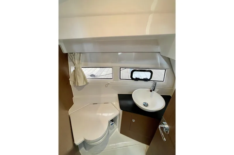Slide: The Image of Modern bathroom in 2023 Jeanneau NC Weekender 895 boat, featuring compact sink and toilet. - 23