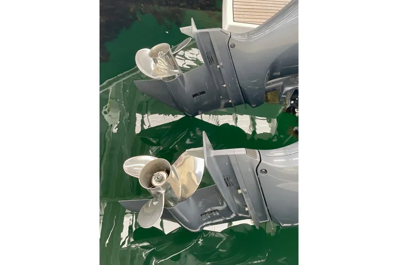 Slide: The Image of Twin outboard motors of a 2023 Jeanneau NC Weekender 895 on calm water. - 7