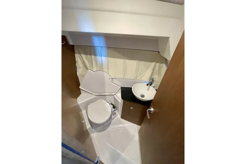 Slide: The Image of Bathroom interior of 2023 Jeanneau NC Weekender 895, featuring compact toilet and sink. - 22