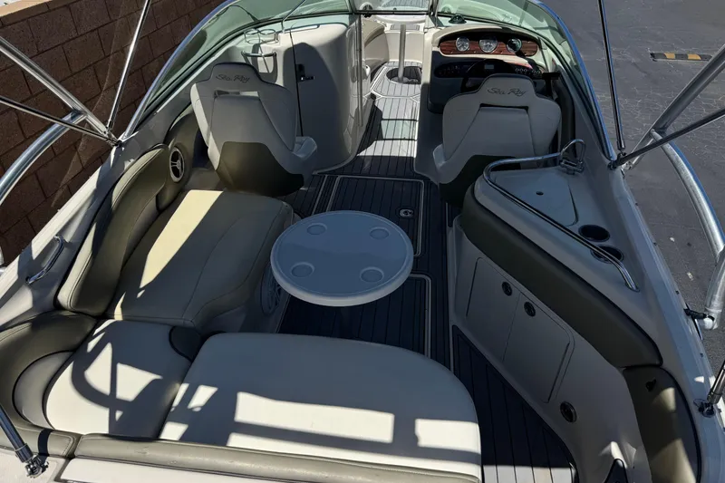 Slide: The Image of 2007 Sea Ray 240 Sundeck interior with seating, table, and helm, showcasing luxury boat design. - 11