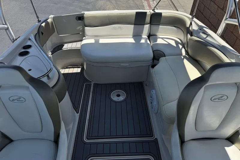 Slide: The Image of Interior of a 2007 Sea Ray 240 Sundeck boat with cushioned seating and cup holders. - 26