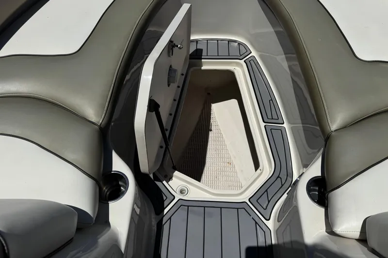 Slide: The Image of 2007 Sea Ray 240 Sundeck interior storage compartment with open hatch and cushioned seating. - 23