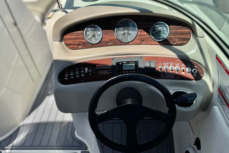 Slide: The Image of 2007 Sea Ray 240 Sundeck dashboard with gauges, steering wheel, and control panel. - 40