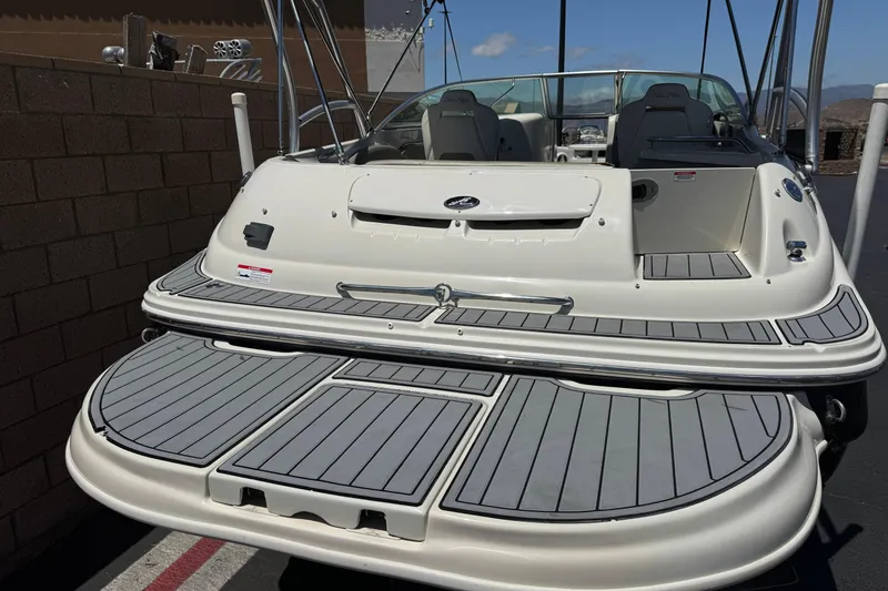 Slide: The Image of 2007 Sea Ray 240 Sundeck boat with spacious deck and seating, docked outdoors. - 6