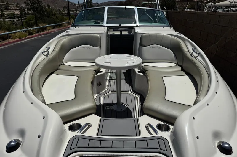 Slide: The Image of 2007 Sea Ray 240 Sundeck boat interior with seating and table, docked outdoors. - 14