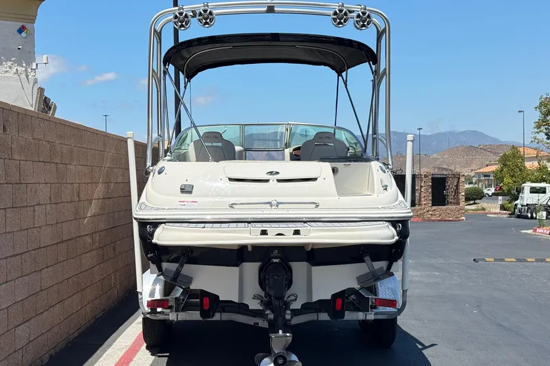 Slide: The Image of 2007 Sea Ray 240 Sundeck boat on trailer, parked outdoors with clear sky. - 4