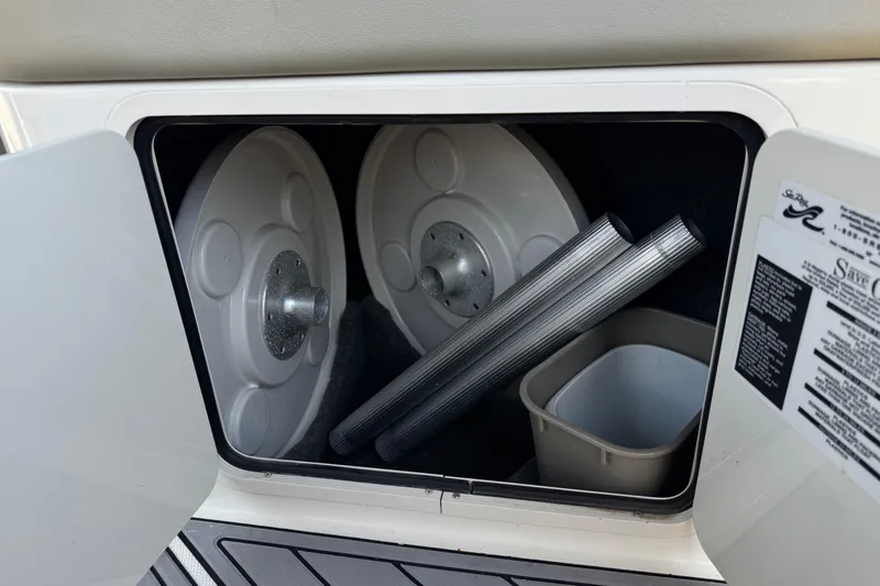 Slide: The Image of Storage compartment in a 2007 Sea Ray 240 Sundeck with accessories and manuals. - 30