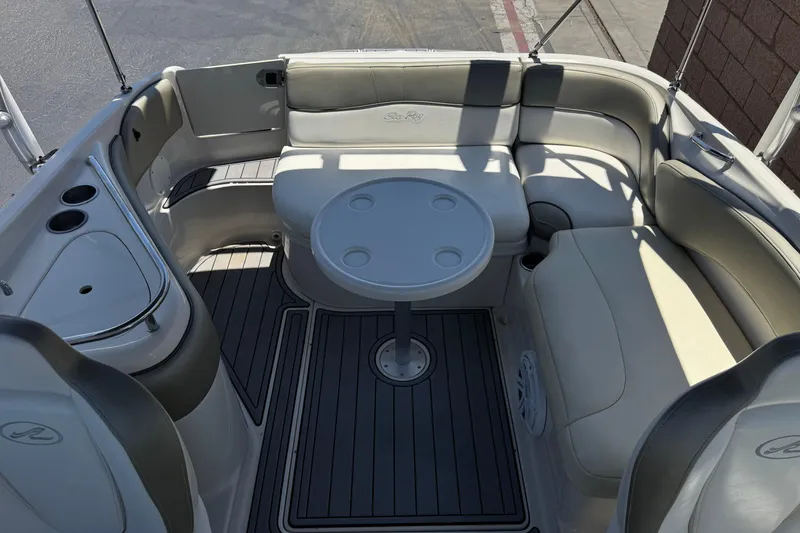 Slide: The Image of 2007 Sea Ray 240 Sundeck interior with seating and table, featuring cup holders. - 25