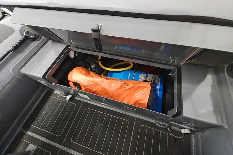 Slide: The Image of Storage compartment of 2023 Highfield Patrol 600 boat with safety equipment and supplies. - 9