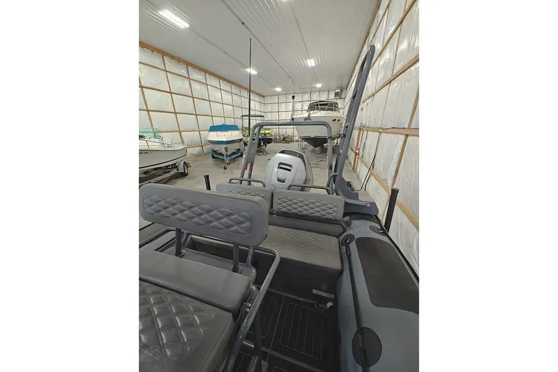 Slide: The Image of 2023 Highfield Patrol 600 boat interior in a storage facility with other boats. - 6