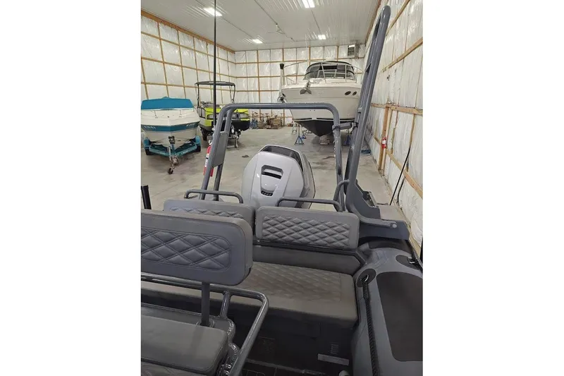 Slide: The Image of 2023 Highfield Patrol 600 boat in storage, featuring sleek interior and multiple boats in background. - 7