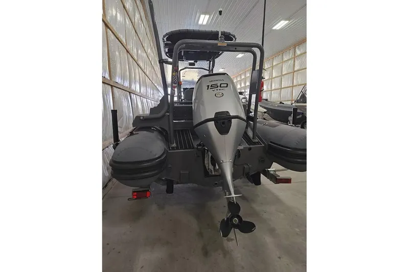 Slide: The Image of 2023 Highfield Patrol 600 boat with Honda 150 VTEC engine in a storage facility. - 12