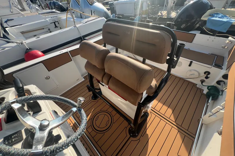 Slide: The Image of 2019 Sea Hunt Ultra 234 boat interior with steering wheel and cushioned seating. - 15