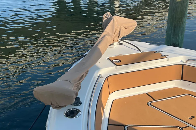 Slide: The Image of 2019 Sea Hunt Ultra 234 boat bow with covered anchor, docked on calm water. - 8