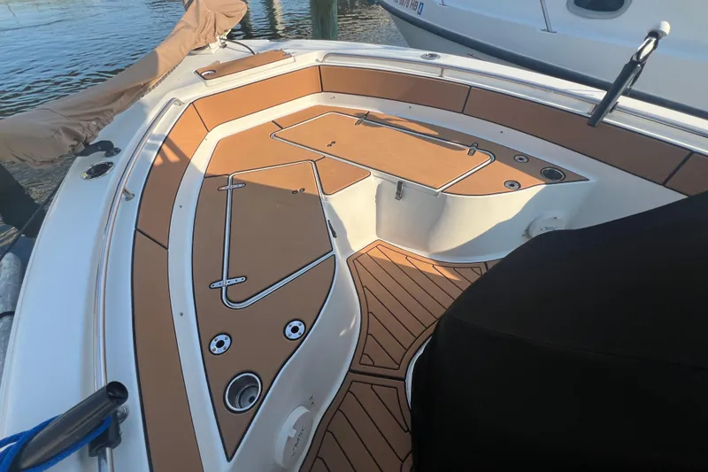 Slide: The Image of 2019 Sea Hunt Ultra 234 boat interior with tan deck and seating area. - 11