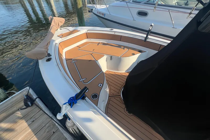 Slide: The Image of 2019 Sea Hunt Ultra 234 boat docked, featuring spacious deck and sleek design. - 7