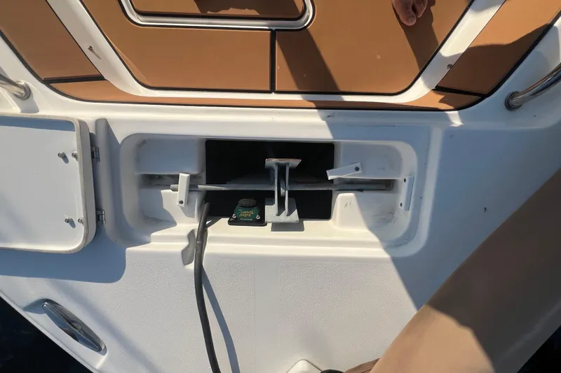 Slide: The Image of 2019 Sea Hunt Ultra 234 boat interior detail with storage compartment and cable. - 20