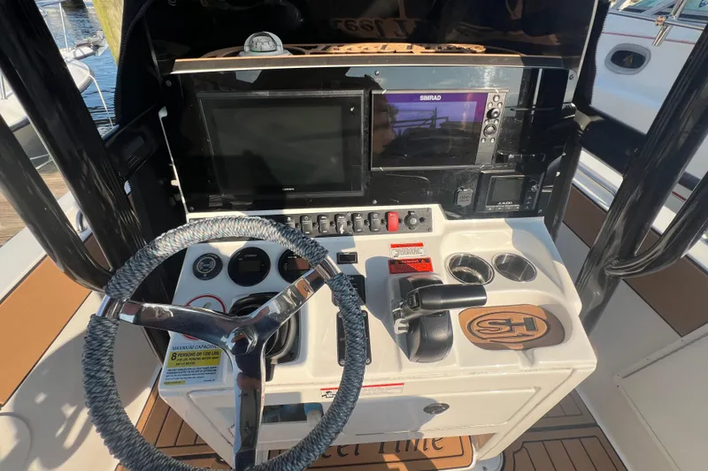 Slide: The Image of 2019 Sea Hunt Ultra 234 boat dashboard with steering wheel and navigation controls. - 13