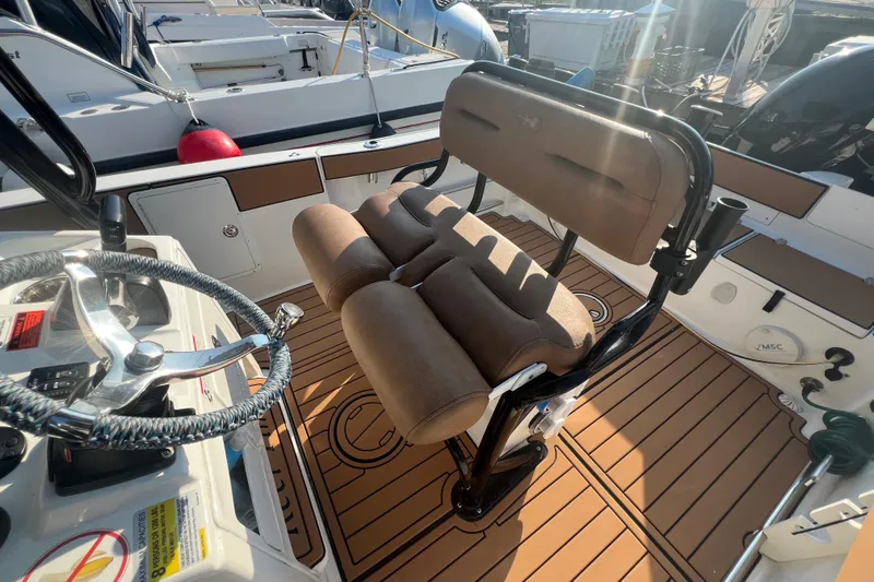 Slide: The Image of 2019 Sea Hunt Ultra 234 boat interior with brown seating and steering wheel. - 16