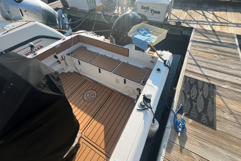 Slide: The Image of 2019 Sea Hunt Ultra 234 boat docked, featuring a clean deck and fishing equipment. - 5