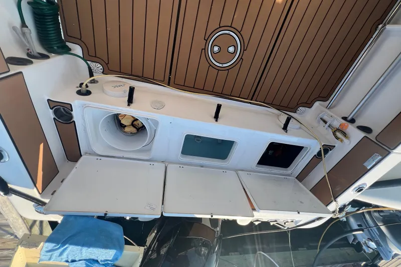Slide: The Image of 2019 Sea Hunt Ultra 234 boat deck with storage compartments and hose. - 9