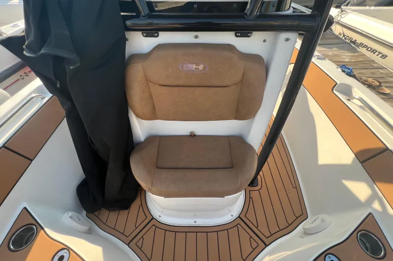Slide: The Image of 2019 Sea Hunt Ultra 234 boat interior with tan seating and teak-style flooring. - 18