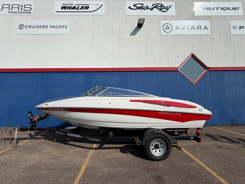 Slide: The Image of A 2006 Crownline 195 boat on a trailer, parked in front of a blue building. - 3