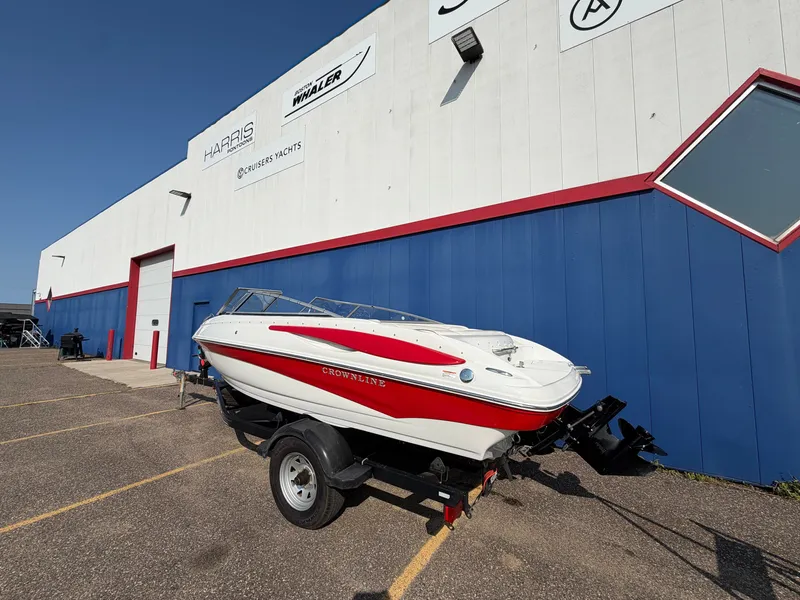 Slide: The Image of A 2006 Crownline 195 boat on a trailer in front of a building. - 2