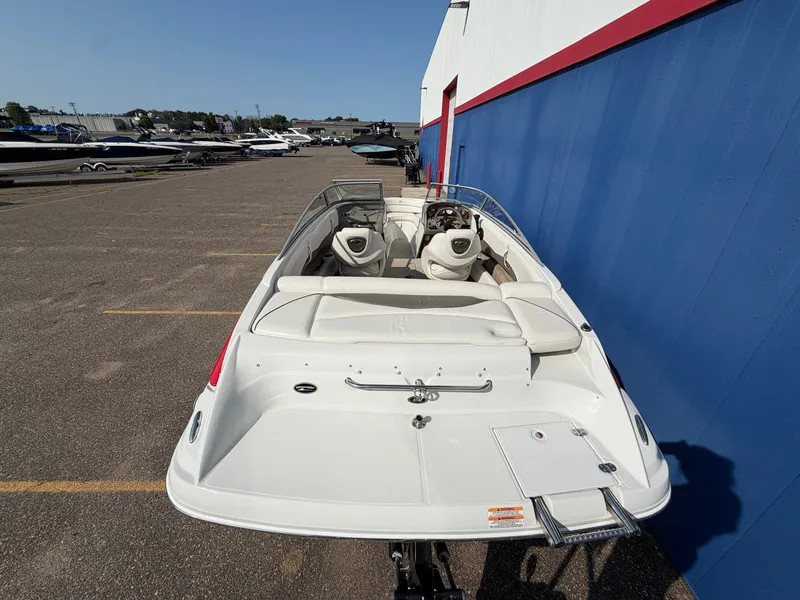Slide: The Image of A 2006 Crownline 195 boat is parked. It features white upholstery and an open cockpit. - 6