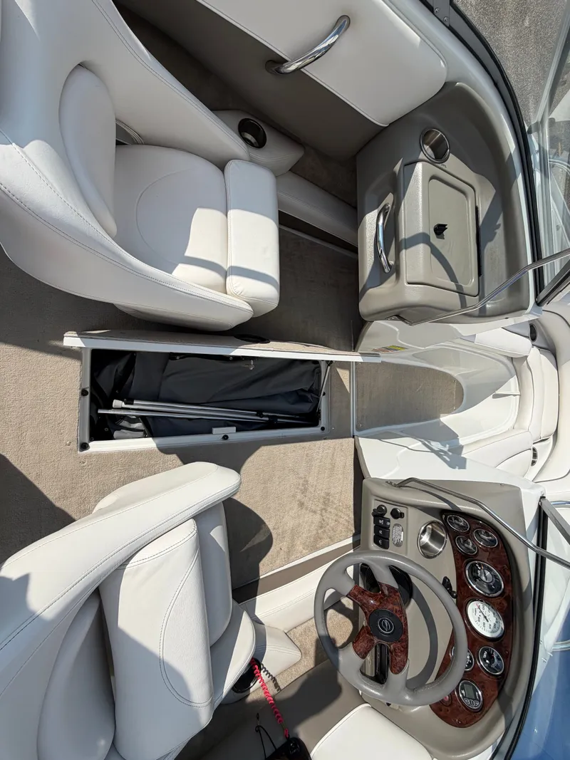 Slide: The Image of Interior of a 2006 Crownline 195 boat with white seats and a sleek dashboard. - 26