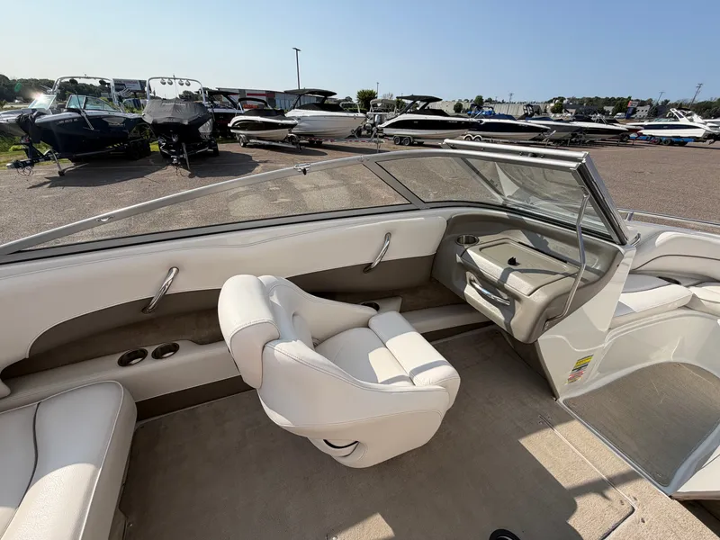 Slide: The Image of The image shows the cockpit of a 2006 Crownline 195 boat with white seats and a clear sky. - 13