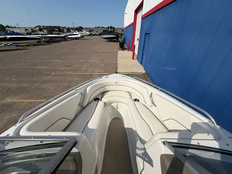 Slide: The Image of The image shows the bow seating area of a 2006 Crownline 195 boat parked on a lot. - 17