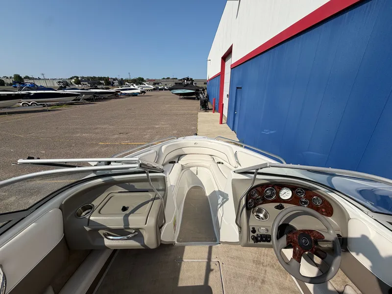 Slide: The Image of The image shows the cockpit of a 2006 Crownline 195 boat parked beside a building. - 18