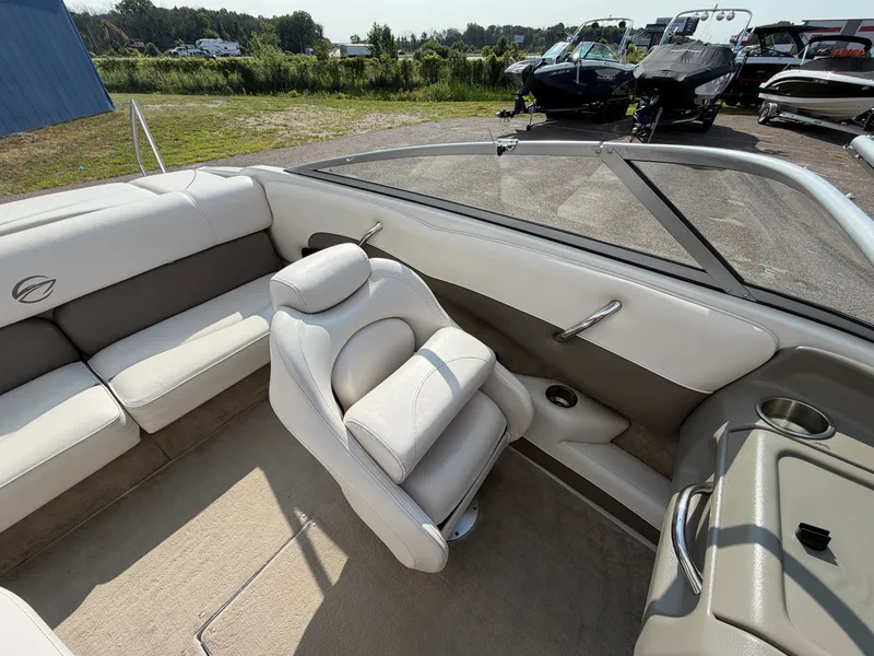 Slide: The Image of The image shows the cockpit of a 2006 Crownline 195 boat with beige upholstery. - 12