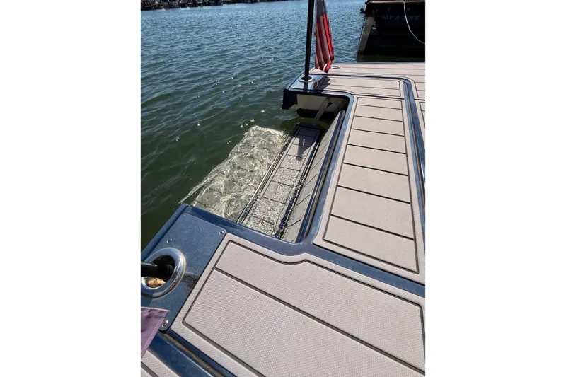 Slide: The Image of 2023 Chaparral 307 SSX boat deck with water view and American flag. - 8